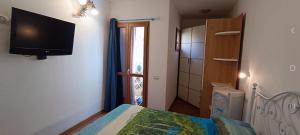 オルビアにあるB&B Marinaのベッドルーム1室(壁にテレビ付)、ベッド1台が備わります。