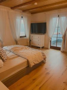 a bedroom with a bed and a dresser with a television at Charmantes Landhaus in Oberteuringen