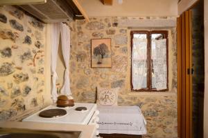 a small kitchen with a stove and a window at A small paradise in Mani with local hospitality in Órva