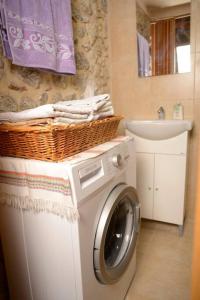 a washing machine with a basket on top of it in a bathroom at A small paradise in Mani with local hospitality in Órva