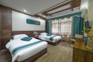 una camera d'albergo con due letti e un tavolo di Mountains Beyond Mountains Inn a Zhangjiajie