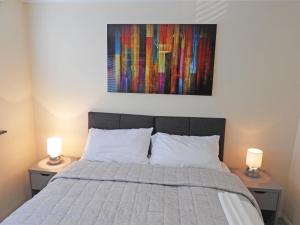 1 dormitorio con 1 cama con 2 lámparas en 2 mesas en A Home from Home - Leamington Spa en Leamington Spa