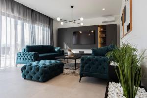 ein Wohnzimmer mit 2 blauen Sofas und einem TV in der Unterkunft Villa Petrea in Novigrad