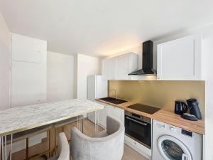 a kitchen with white cabinets and a washer and dryer at 2 pièces - Parking - Jacuzzi - Food & Drink - Love in Menton