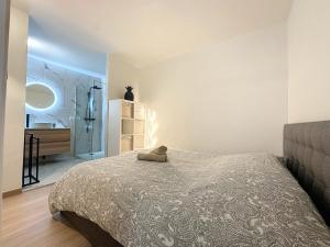 a bedroom with a bed and a bathroom with a sink at 2 pièces - Parking - Jacuzzi - Food & Drink - Love in Menton