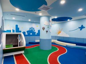 um quarto para crianças com uma área recreativa com um mural de parede em Holiday Garden Hotel SKM Park em Kaohsiung