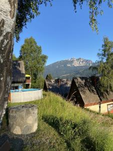 a view of a farm with mountains in the background at Das kleine Feriendorf in Carinthia