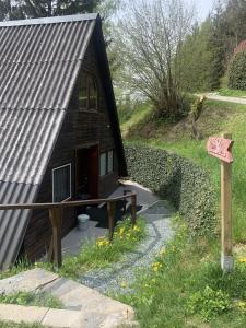 una pequeña casa con un cartel delante en Das kleine Feriendorf en Karnten