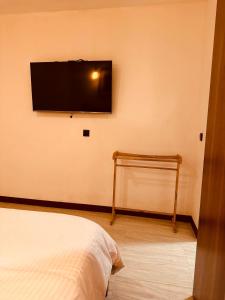 a bedroom with a flat screen tv on the wall at ODI KAMADHOO in Kamadhoo