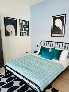 a bedroom with a large bed with blue pillows at Elegant 1st Floor 1BR Belsize Park Apartment in London