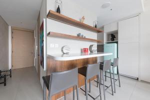 a kitchen with a bar with chairs and a refrigerator at Fabulous 1BR apartment in Address Beach Resort in Dubai