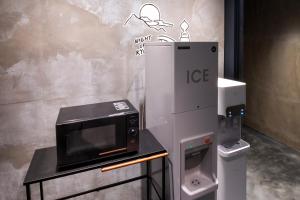 京都市にあるhotel Bell・Kyotoの製氷機の横のテーブルに電子レンジ
