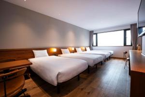 a row of beds in a row in a room at hotel Bell・Kyoto in Kyoto +34 photos