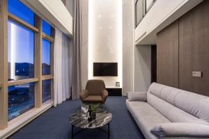 a living room with a couch and a chair at Centum Premier Hotel in Busan +46 photos