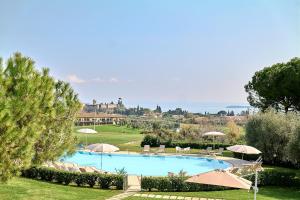 a large swimming pool with umbrellas and the ocean at Moniga Resort in Moniga