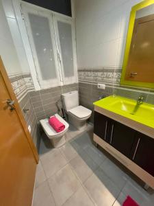een badkamer met een toilet en een gele wastafel bij A las puertas de la Catedral 90m2 con Garaje in Vitoria-Gasteiz