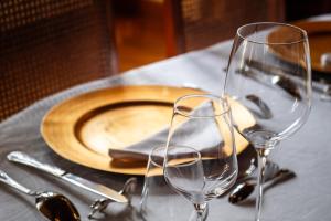 stół z talerzem i dwa kieliszki do wina w obiekcie Château de Thorens w mieście Thorens-Glières