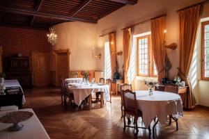 a dining room with tables and chairs and windows at Château de Thorens in Thorens-Glières