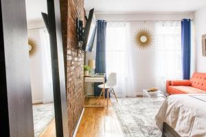 um quarto com um sofá vermelho e uma parede de tijolos em 26-3A STUDIO Gramercy W D Outdoor Courtyard em Nova York