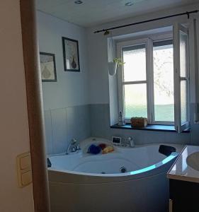 baño con bañera grande y ventana en Staufenhof, en Bad Reichenhall