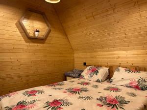 ein Schlafzimmer mit einem Bett in einer Holzhütte in der Unterkunft A Frame Lankaran in Länkäran