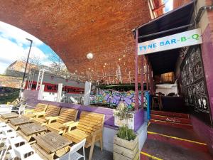 un restaurante con mesas y sillas de madera y graffiti en Chapter Homes Newcastle, en Saint Peters