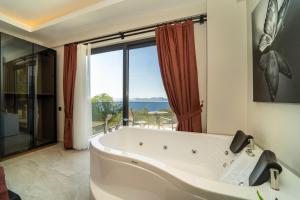 y baño con bañera y ventana grande. en Villa Mariposa en Fethiye