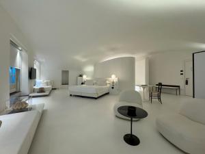 Hotel Palazzo Durazzo Suites في جينوا: غرفة معيشة بيضاء مع أريكة وسرير