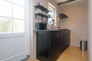 ノールトウェイクにあるHave a nice stay! - The Dutch nabij strand en boulevardのキッチン(黒いカウンター、窓付) +11枚の写真