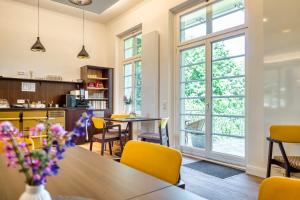 une cuisine et une salle à manger avec une table et des chaises jaunes dans l'établissement Familienferienpark Dambeck, à Kratzeburg