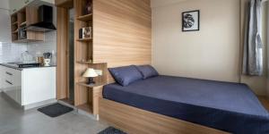 ein kleines Schlafzimmer mit einem Bett und einer Küche in der Unterkunft Wandr Centauri in Bangalore