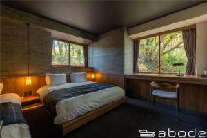 Un dormitorio con una cama grande y una ventana en abode villa GORA 八代別邸, en Onsensō