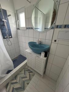 a bathroom with a blue sink and a mirror at Aurora Apartman in Harkány