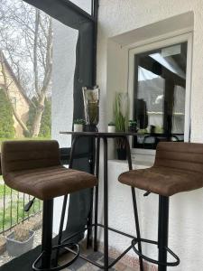 uma mesa e duas cadeiras em frente a uma janela em Aurora Apartman em Harkány