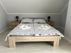 a bedroom with a bed with two shoes on it at Aurora Apartman in Harkány