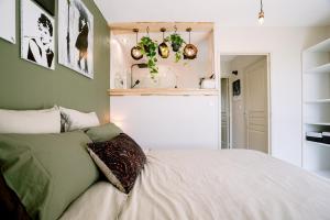 ein Schlafzimmer mit einem weißen Bett und einigen Pflanzen in der Unterkunft Vue sur le golf chez les grats-piscine-clim in Rivières