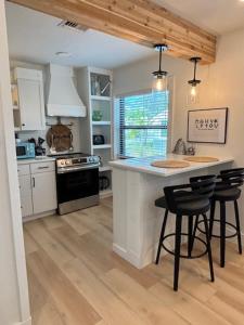 a kitchen with a island with chairs and a stove at Cracker Cow Cottages - Cottage A in Fort Myers
