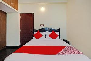 ein Schlafzimmer mit einem großen Bett mit roten Kissen in der Unterkunft OYO Blooms Inn in Bangalore