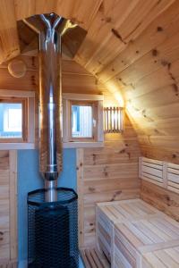 uma cabina de madeira com um grande fogão a lenha num quarto em Stijlvol appartement met jacuzzi & sauna em Herk-de-Stad