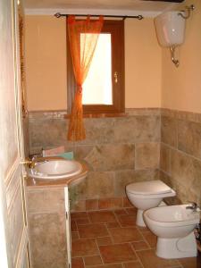 een badkamer met een wastafel, een toilet en een raam bij Casa Roberto - Campagna Toscana vicino al mare in Castellina Marittima