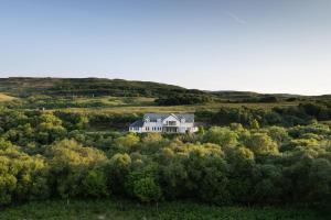 a large white house in the middle of a field at Killoran House in Dervaig