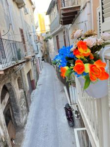 a narrow alley with flowers hanging from buildings at Borgo Levano in Licata