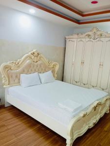 - une chambre avec un lit blanc et une armoire blanche dans l'établissement KHÁCH SẠN HOÀNG TRIỀU, à Chánh Long