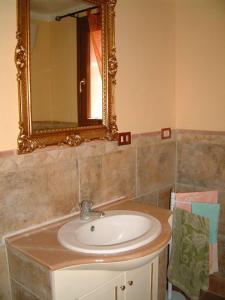 een badkamer met een wastafel en een spiegel bij Casa Roberto - Campagna Toscana vicino al mare in Castellina Marittima