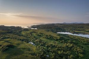 an aerial view of a golf course with a lake at Killoran House in Dervaig