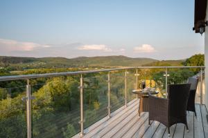 a balcony with two chairs and a table on it at Killoran House in Dervaig