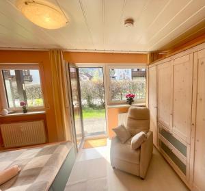 a room with a chair and a bed and windows at Ferienwohnung Singer in Bad Reichenhall +7 photos