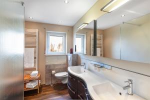 a bathroom with a sink and a toilet at Hotel Garni Sonnengruss in Hagnau +44 photos