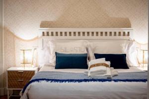 een slaapkamer met een wit bed met blauwe kussens bij Anne Apartamento in Gijón