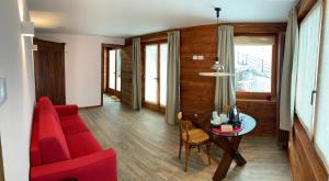 sala de estar con sofá rojo y mesa en lo Miete di Nonni en Champoluc